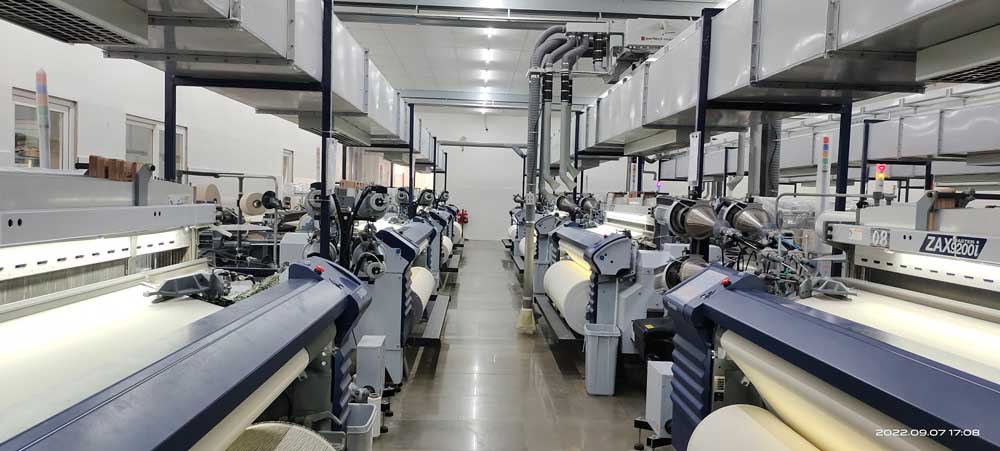Large textile manufacturing unit with weaving machines.