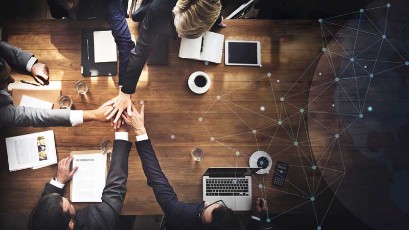 Corporate team joining hands in unity and collaboration – Dharmshil Group