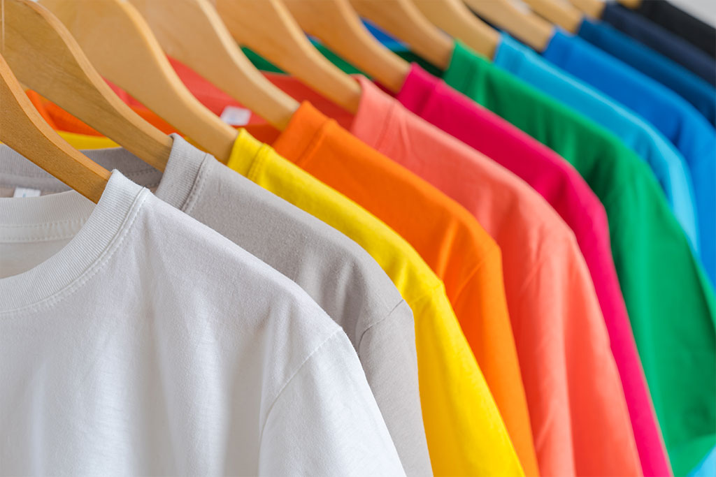Assorted colorful t-shirts displayed for international apparel export – Dharmshil Group